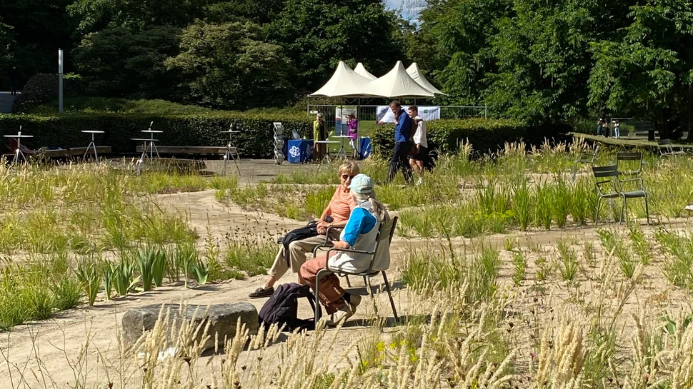 Besucher des Planten un Blomen Wildpflanzen-Garten sitzen auf zwei Stühlen