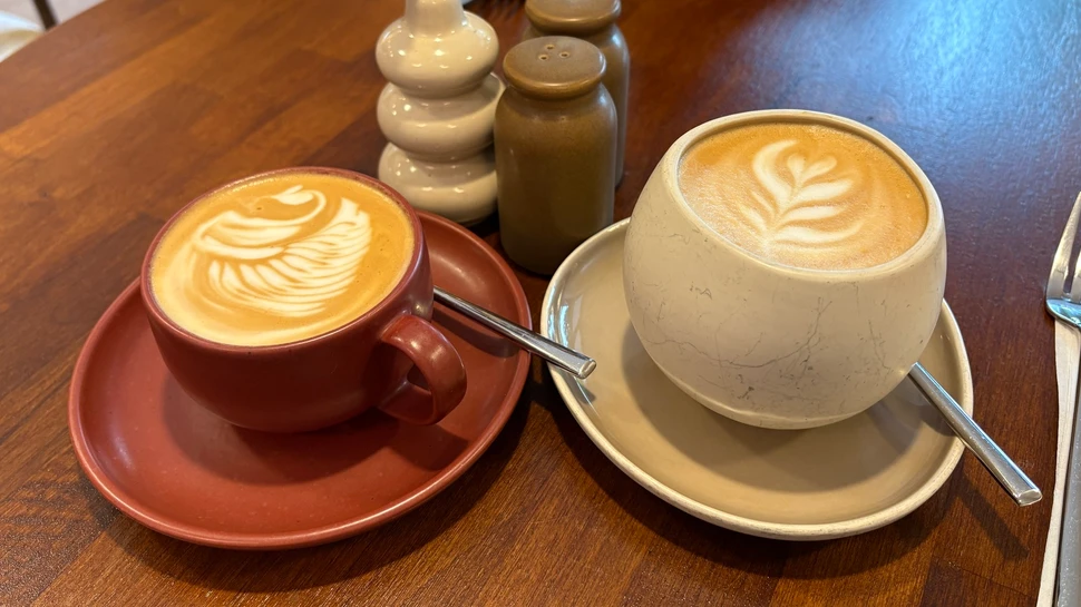 Cappuccino und Milchkaffee in schönen Keramiktassen auf dem Tisch