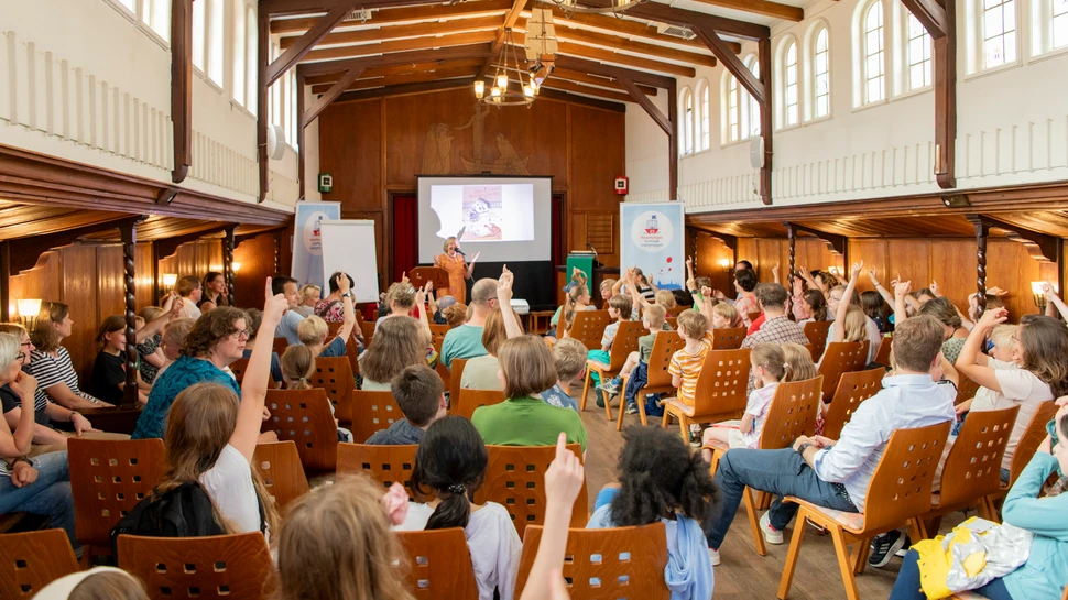 Lesung beim Hamburger VorleseVergnüge Kinder sitzen in der Flussschifferkirche und hören einer Lesung zu