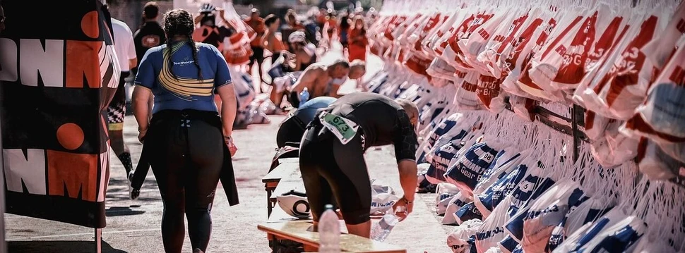 Ironman Wechselzone Athleten und Athletinnen in der Wechselzone vom Ironman, daneben hängen die Beutel