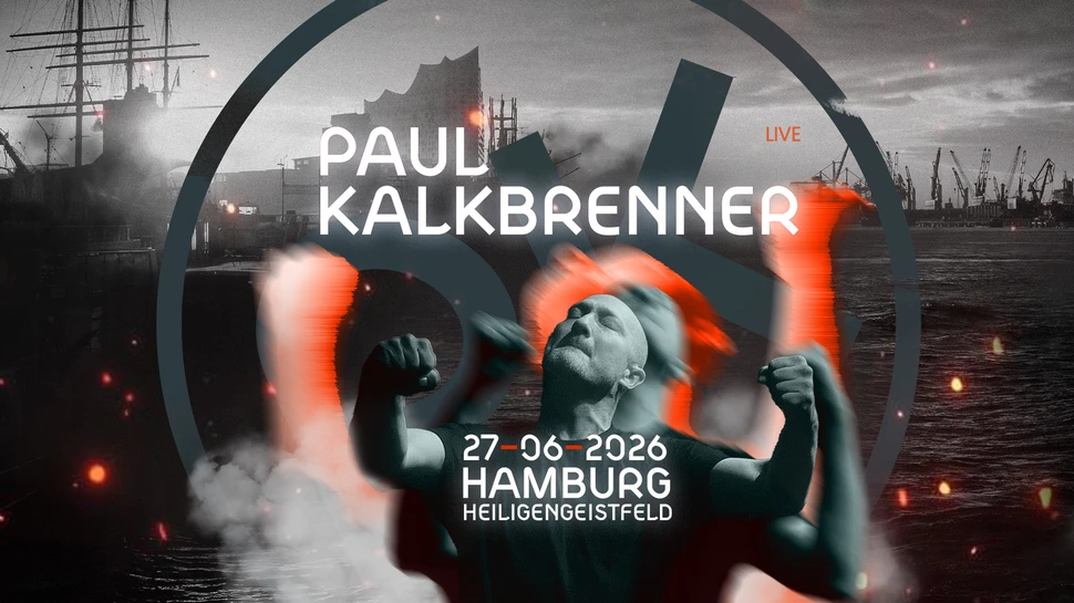 Paul Kalkbrenner mit geballten Fäusten, hinter ihm die Kulisse des Hamburger Hafens
