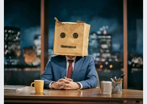 Talkshow-Moderator mit Papiertüte über dem Kopf auf die ein Gesicht gezeichnet wurde