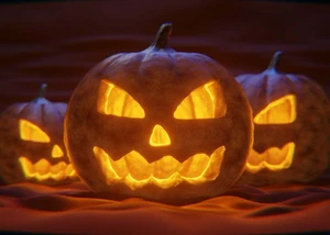 Halloween Drei ausgehöhlte Kürbisse mit geschnitztem Gesicht, die von innen beleuchtet sind.