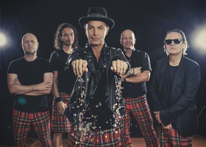 fünf Mitgliedern einer Band mit rot-karierten Hosen und schwarzen Oberteilen
