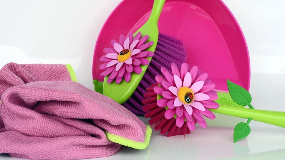 rosa Putzlappen, bunte Spülbürste und Handfeger mit Blütendeko