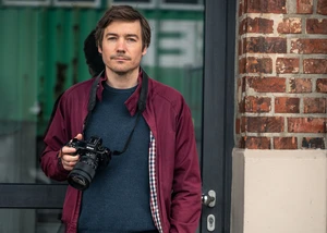 Fotograf schaut durch Spiegelreflexkamera