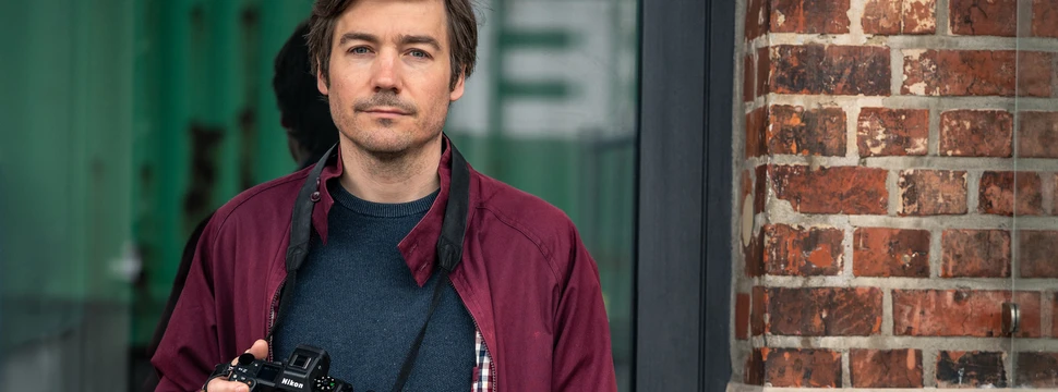 Fotograf mit der Spiegelreflexkamera in der rechten Hand