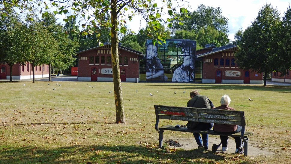 zwei Personen auf einer Bank vor dem Auswanderermuseum Ballinstadt