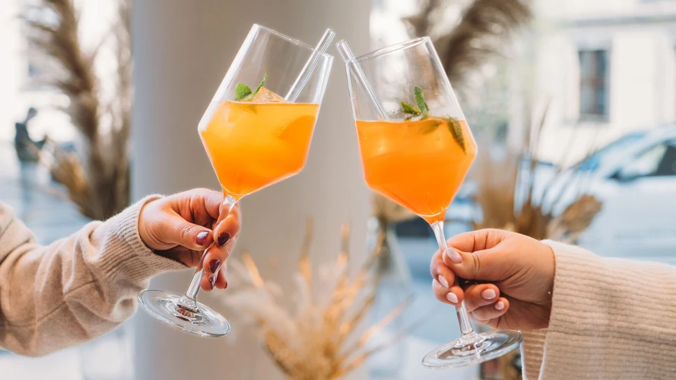 zwei Gläser mit Aperol Spritz beim Anstoßen