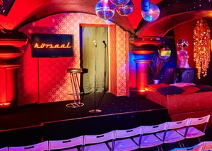 Raum im Hörsaal, bestuhlt mit Mikro auf der Bühne