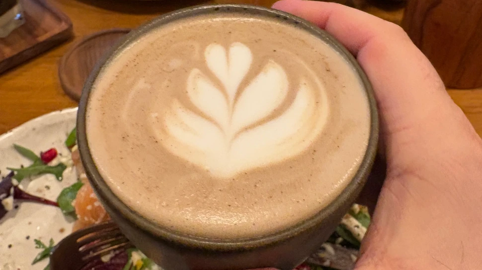 Ein Pumpkin Spice Latte mit Blütenmuster im Milchschaum