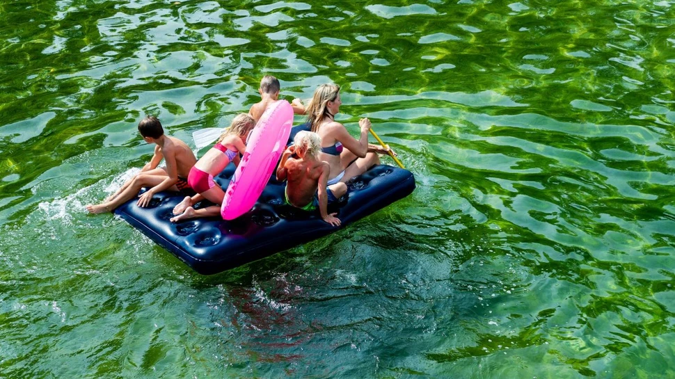 Mutter mit vier Kindern auf einer Wassermatratze auf dem See unterwegs