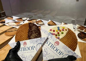 Eine Stroopwaffel mit dunkler Schokolade und Nüssen und eine Waffel mit weißer Schokolade und Schokolinsen