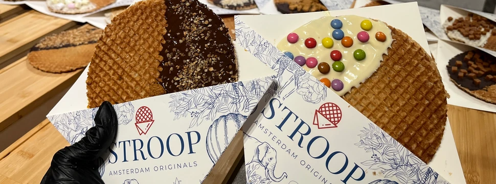 Eine Stroopwaffel mit dunkler Schokolade und Nüssen und eine Waffel mit weißer Schokolade und Schokolinsen