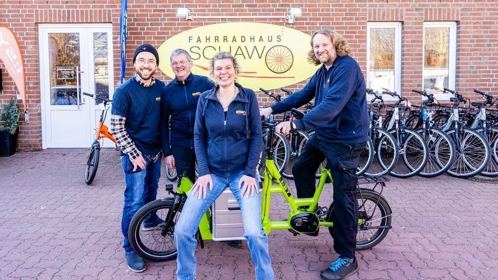 vier Personen vor einem Fahrradladen