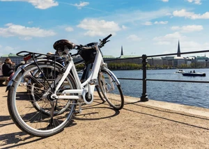 Zwei e-Bikes stehen vor einem Geländer an der Alster