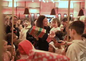 Alleinerziehende mit ihren Kindern packen Geschenke aus