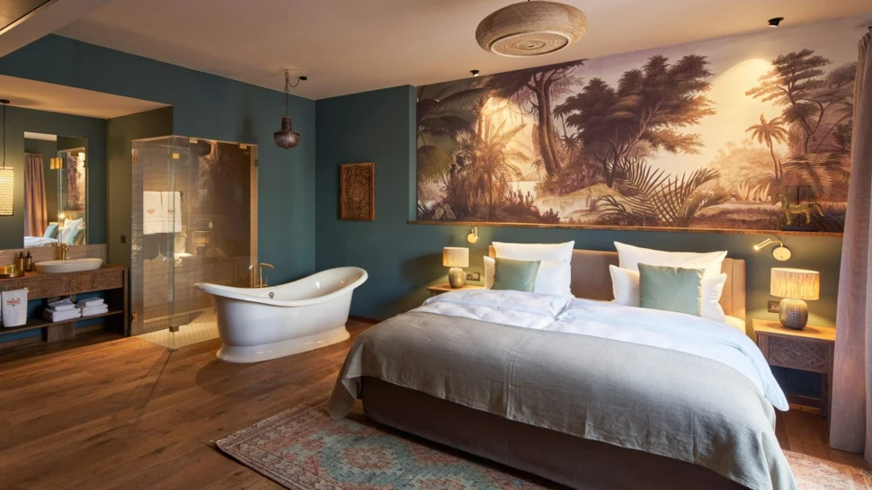 Suite im vabali Hotel Hamburg mit einem großen Doppelbett und Badewanne im Raum.