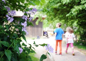 Zwei Kinder laufen über Pflastersteine