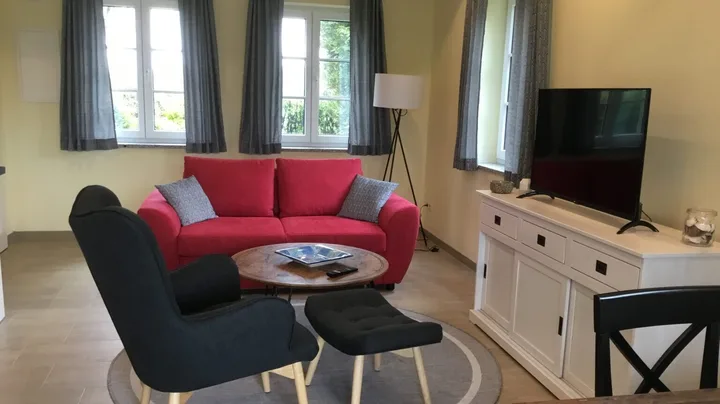 Galerie-Bild 2: Wohnzimmer im Ferienhaus Möwe mit Fernseher, Sesseln und Couch