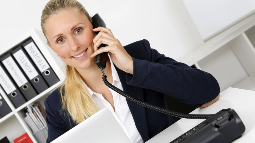 Frau hält sich einen Hörer an das Ohr zum Telefonieren