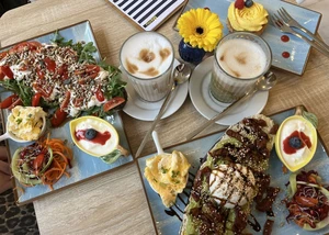 Brunch-Tisch mit zwei Stullen, Latte Macchiatos und gelbem Safran-Cupcake.