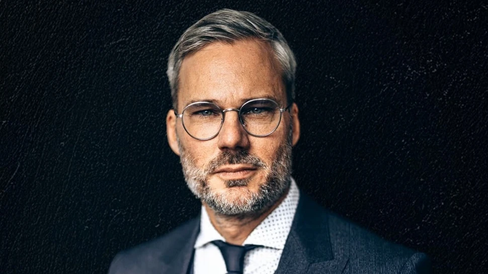 Abbildung von einem Mann im dunklen Anzug vor schwarzem Hintergrund