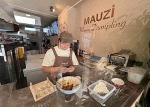 Dumplingmacherin macht frische Dumplings im Restaurant Mauzi