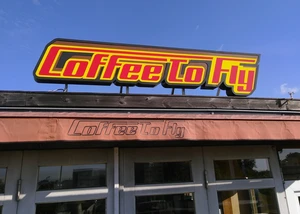 Coffee to Fly Schriftzug auf dem Dach des Cafés