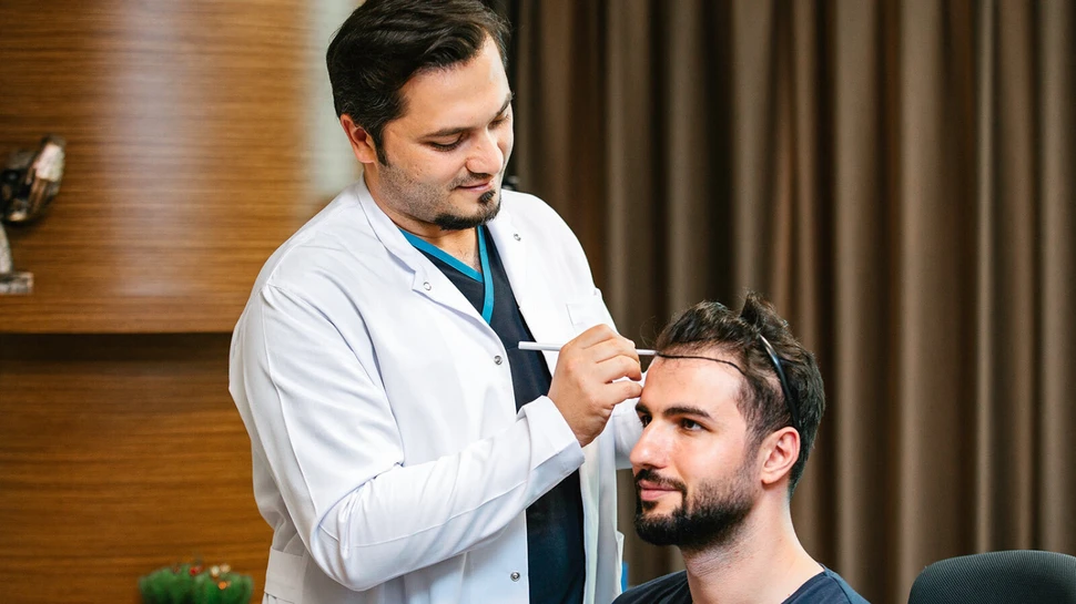 Dr. Abdulaziz Balwi mit einem Patienten beim Einzeichnen der Haarlinie