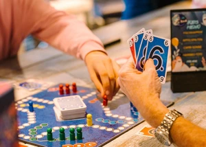 Man sieht die Hände von zwei Personen, die Gesellschaftsspiele spielen