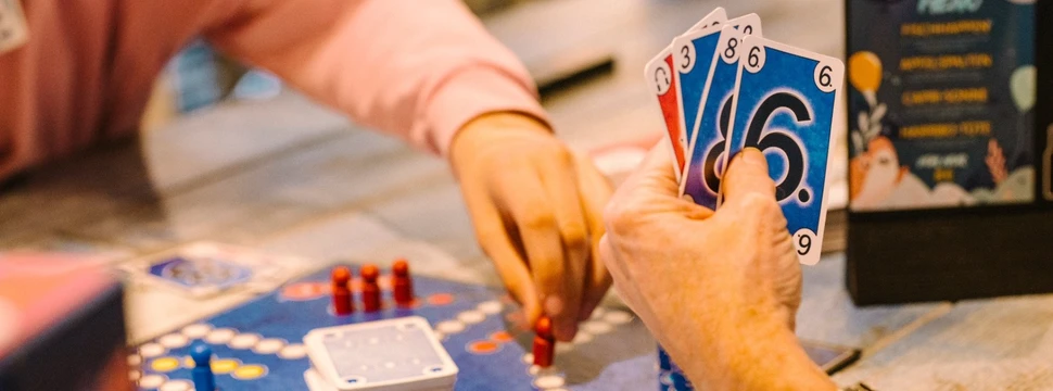 Man sieht die Hände von zwei Personen, die Gesellschaftsspiele spielen