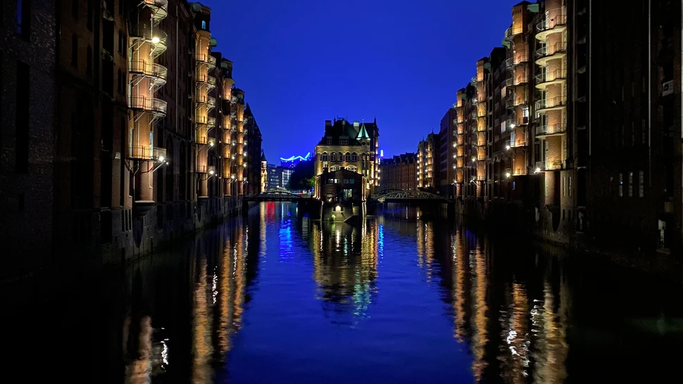 Die Speicherstadt mit dem Wasserschloss und mit Spiegelung des blauen Lichtes beim Blueport Hamburg
