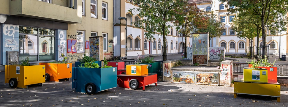 Bunte Hochbeete auf einem Platz in der Stadt
