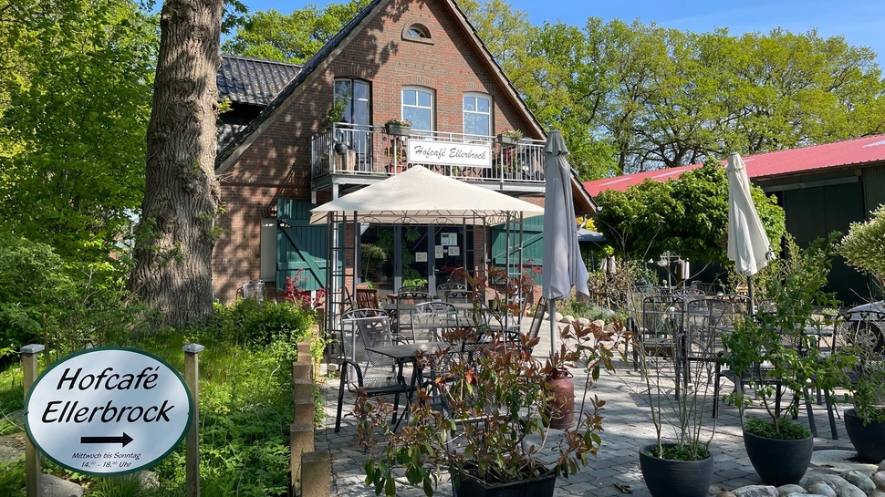 Terrasse mit Tischen und Stühlen in einem Hofcafé