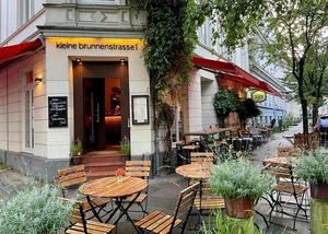 kleine Bistrotische vor einem Restauranteingang