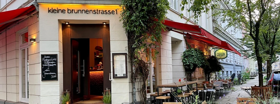 kleine Bistrotische vor einem Restauranteingang