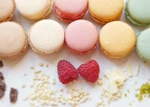 Bunte Macarons und 2 Himbeeren