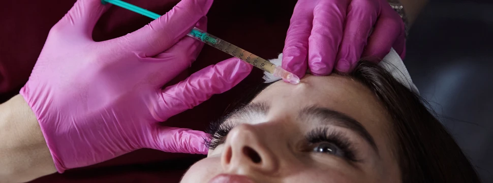 Liegende Frau bekommt eine Gesichtsbehandlung mit Botox