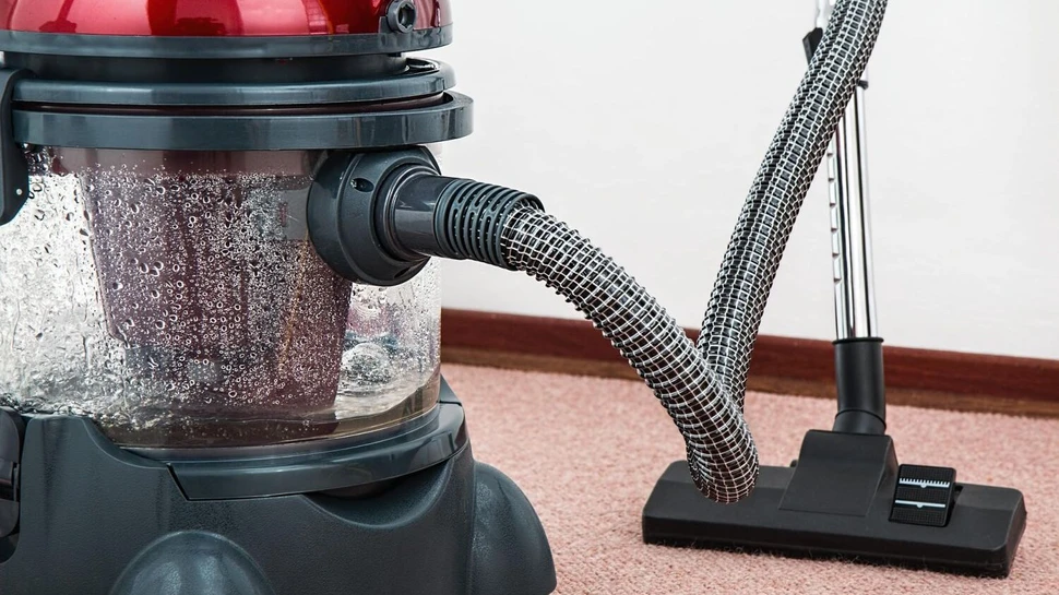 Staubsauger steht auf einem Teppichboden