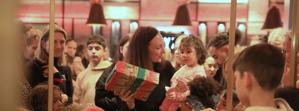 Alleinerziehende mit ihren Kindern packen Geschenke aus