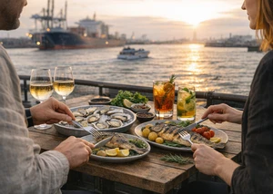 zwei Personen essen Fisch mit Blick auf den Hamburger Hafen