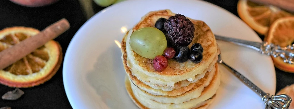 Pancakes auf einem Teller mit Früchten garniert