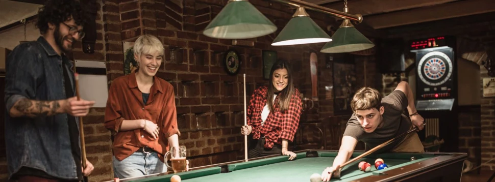 Zwei Frauen und zwei Männer Billard spielen Billard