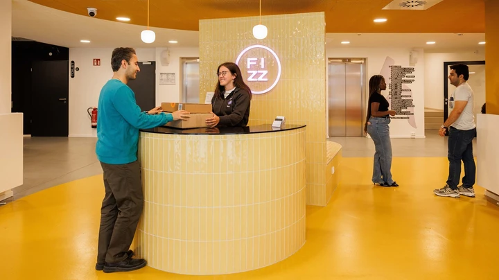 Galerie-Bild 7: gelber Eingangsbereich und Rezeption im THE FIZZ Hammerbrook mit mehreren Personen